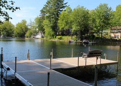 Aluminum Dock With A Bench Overlooking A Lake.